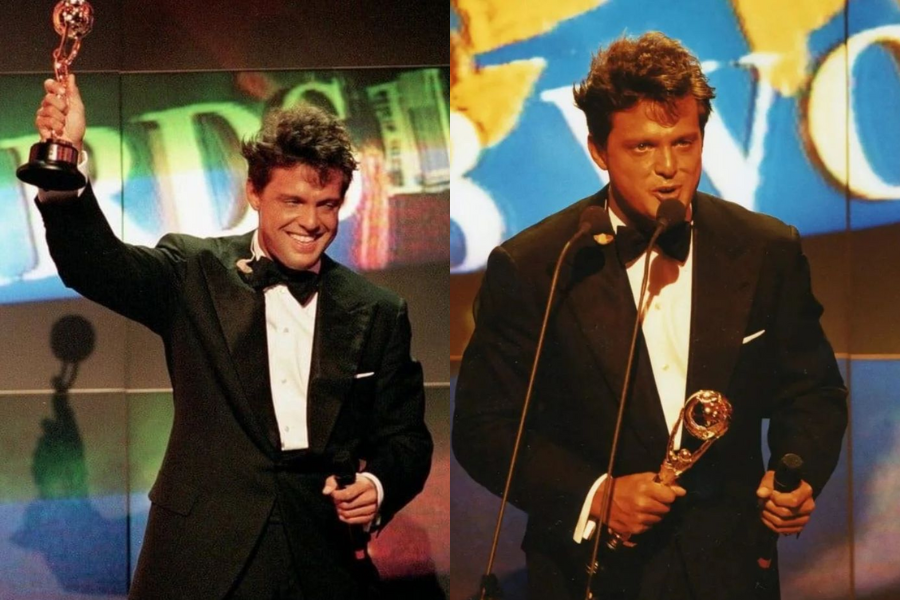 Side-by-side photo of a man with dark, wavy hair in a tuxedo on a stage with a bright, colorful background. On the left, he smiles broadly, holding a golden trophy high with one hand and a microphone in the other. On the right, he is speaking into a microphone, holding a similar golden trophy in his other hand.