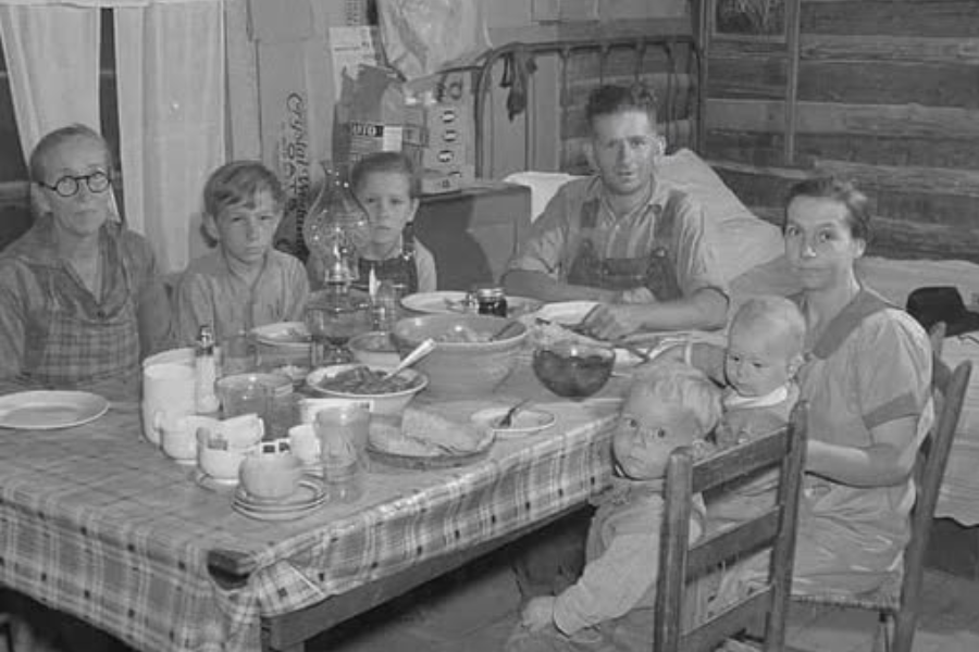 Tipical American Family Eating dinner around the table sitting in a cabin.