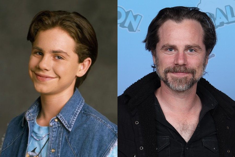 Side-by-side image of a boy and a man. On the left, a smiling young boy with short dark hair wears a denim vest over a T-shirt and beaded necklace, posing against a dark backdrop. On the right, an adult man with medium-length dark hair, a graying beard, and a black jacket smiles gently at a public event with a light blue backdrop.