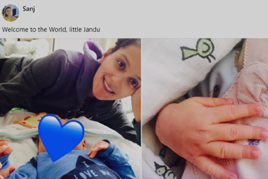 A social media post from Sanj reads “Welcome to the World, little Jandu” and includes two images: one of a smiling woman lying beside a baby whose face is covered with a blue heart emoji, and another close-up of the baby’s tiny hand resting on a soft blanket.