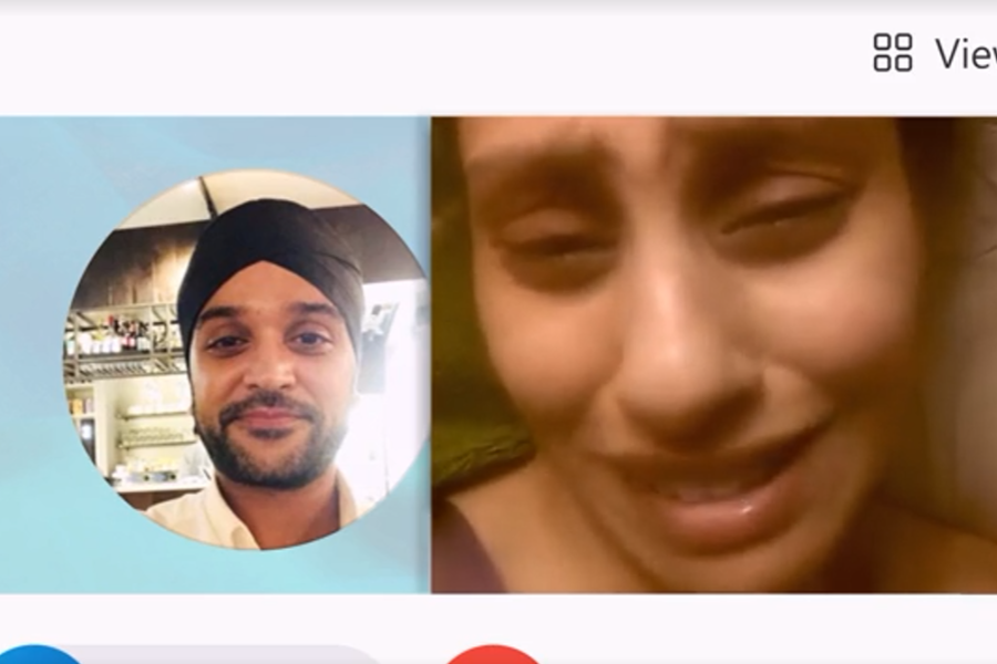 A video call screen shows a man in a turban smiling softly on the left, and a woman on the right appearing distressed or emotional, with tears in her eyes. The interface shows standard call controls at the bottom.