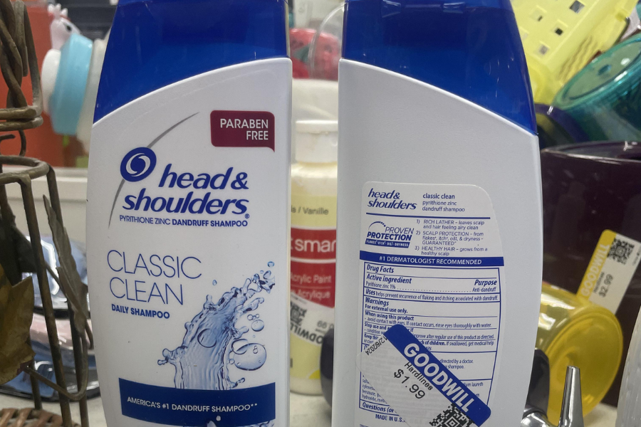Front and back views of Head & Shoulders Classic Clean Daily Shampoo bottles with a blue flip cap, displayed at a Goodwill store with a price tag of $1.99 on the back label.