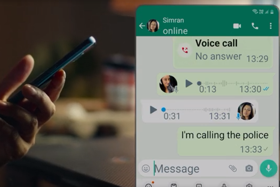 A person holds a smartphone while a WhatsApp chat with Simran is shown on screen. The conversation includes a missed voice call at 13:29, exchanged voice notes, and a final message from Simran saying, “I’m calling the police” at 13:33.